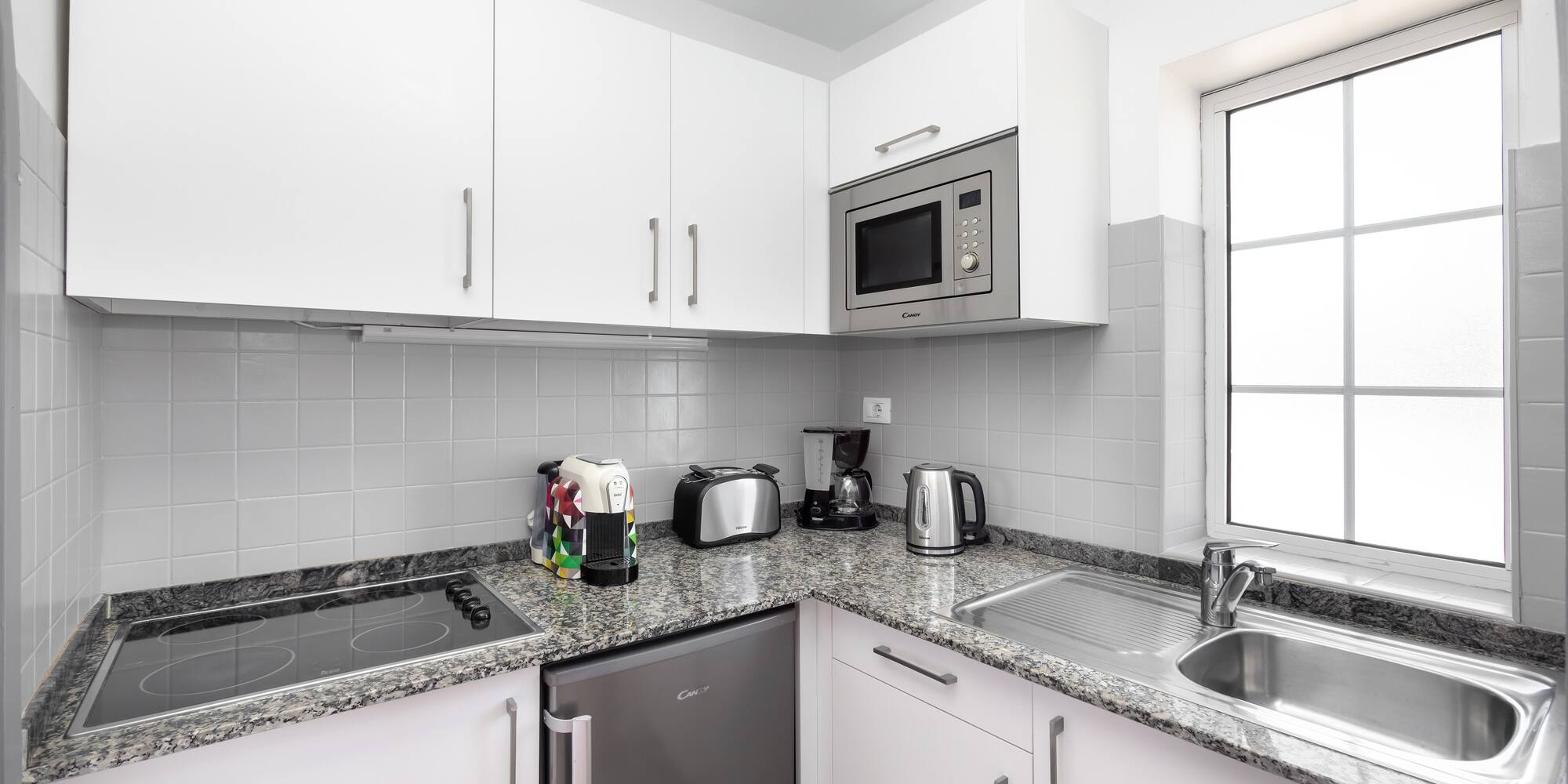 a kitchen with white cabinets and appliances