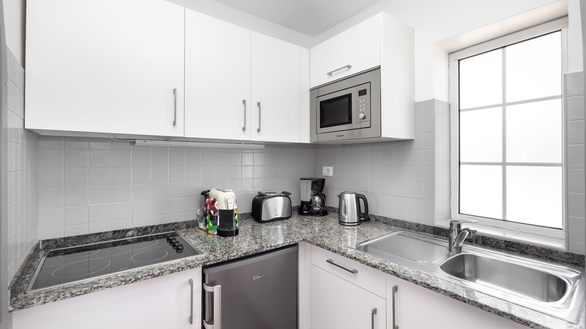 a kitchen with white cabinets and appliances