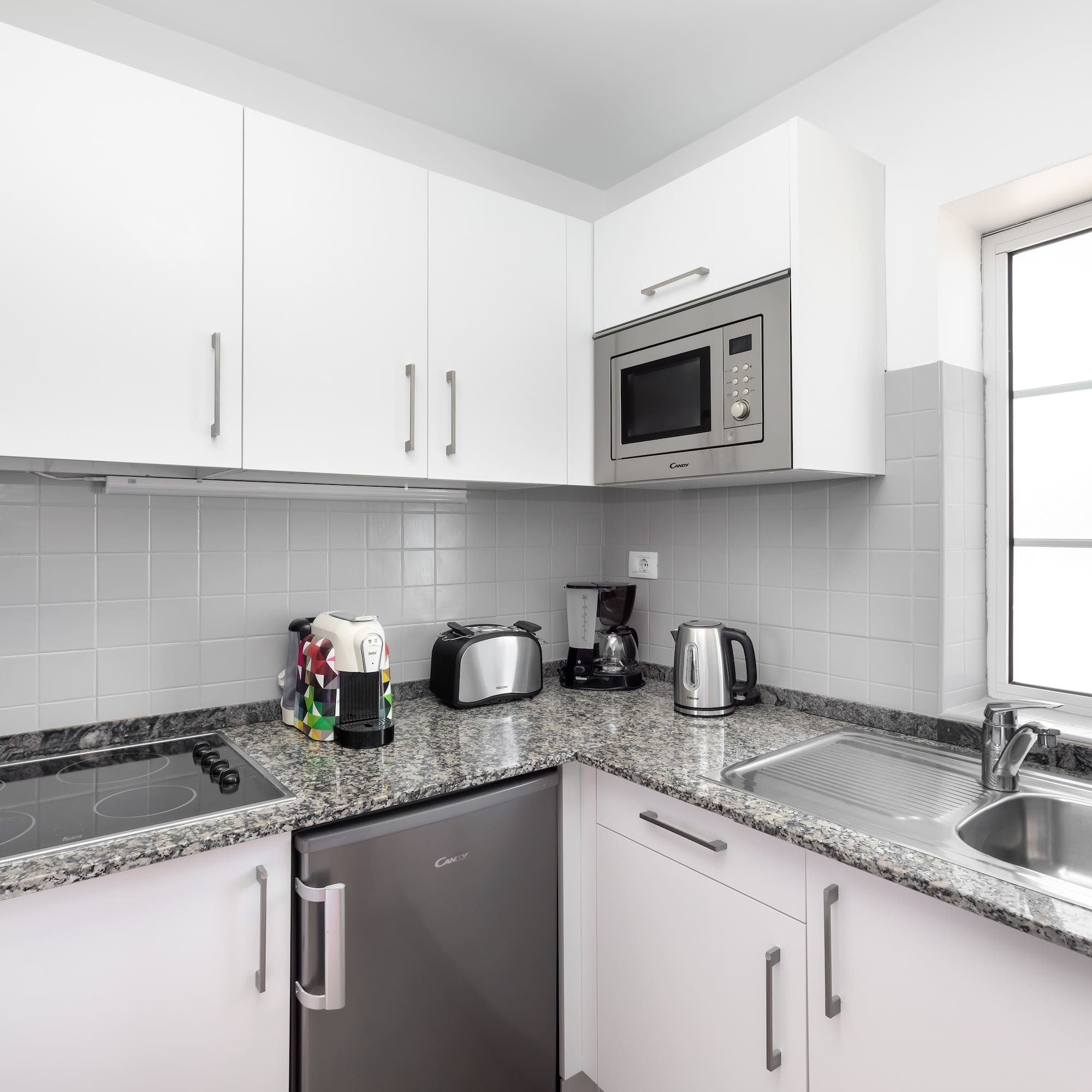 a kitchen with white cabinets and appliances