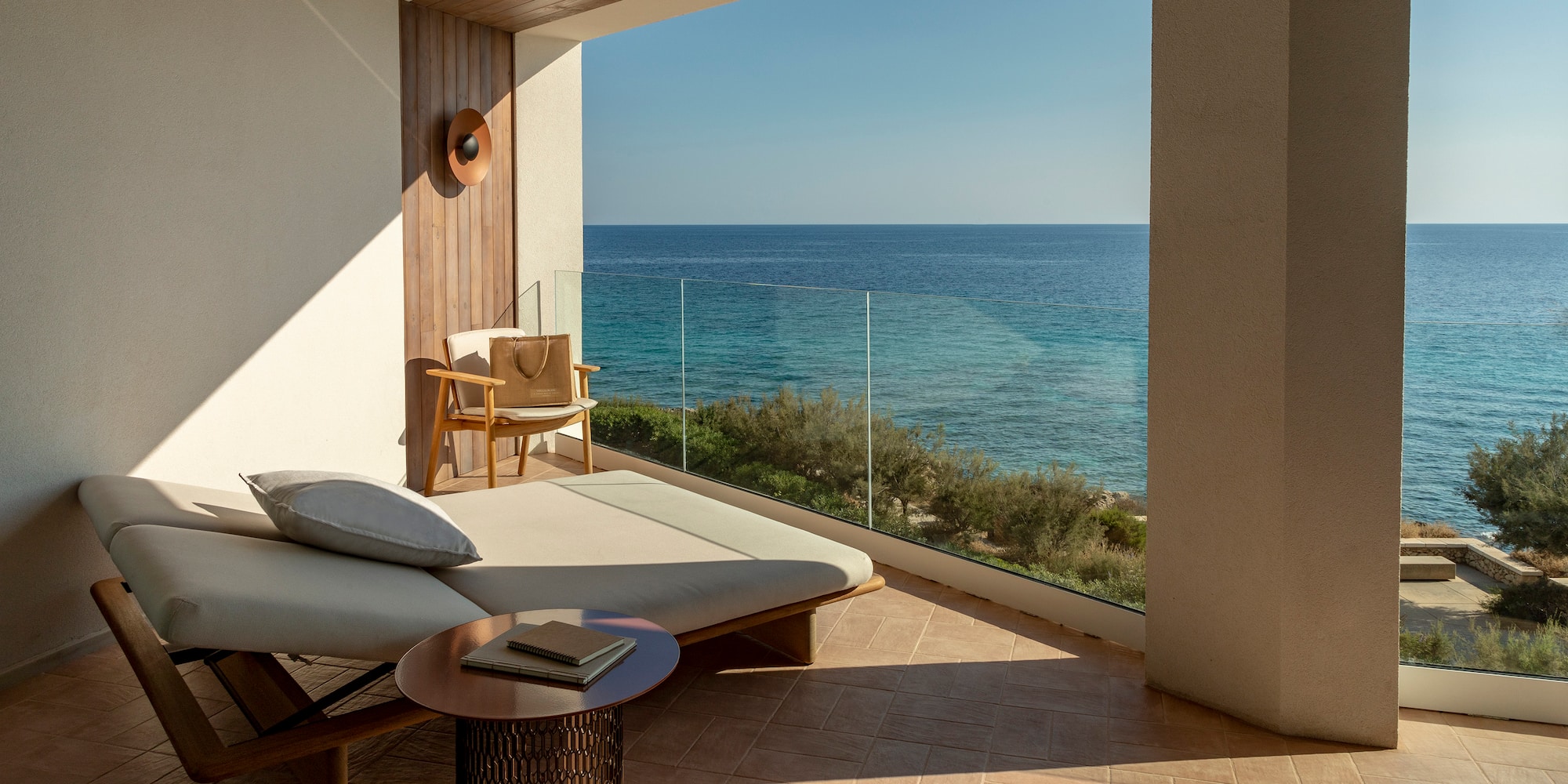 a lounge chair and a table overlooking the ocean