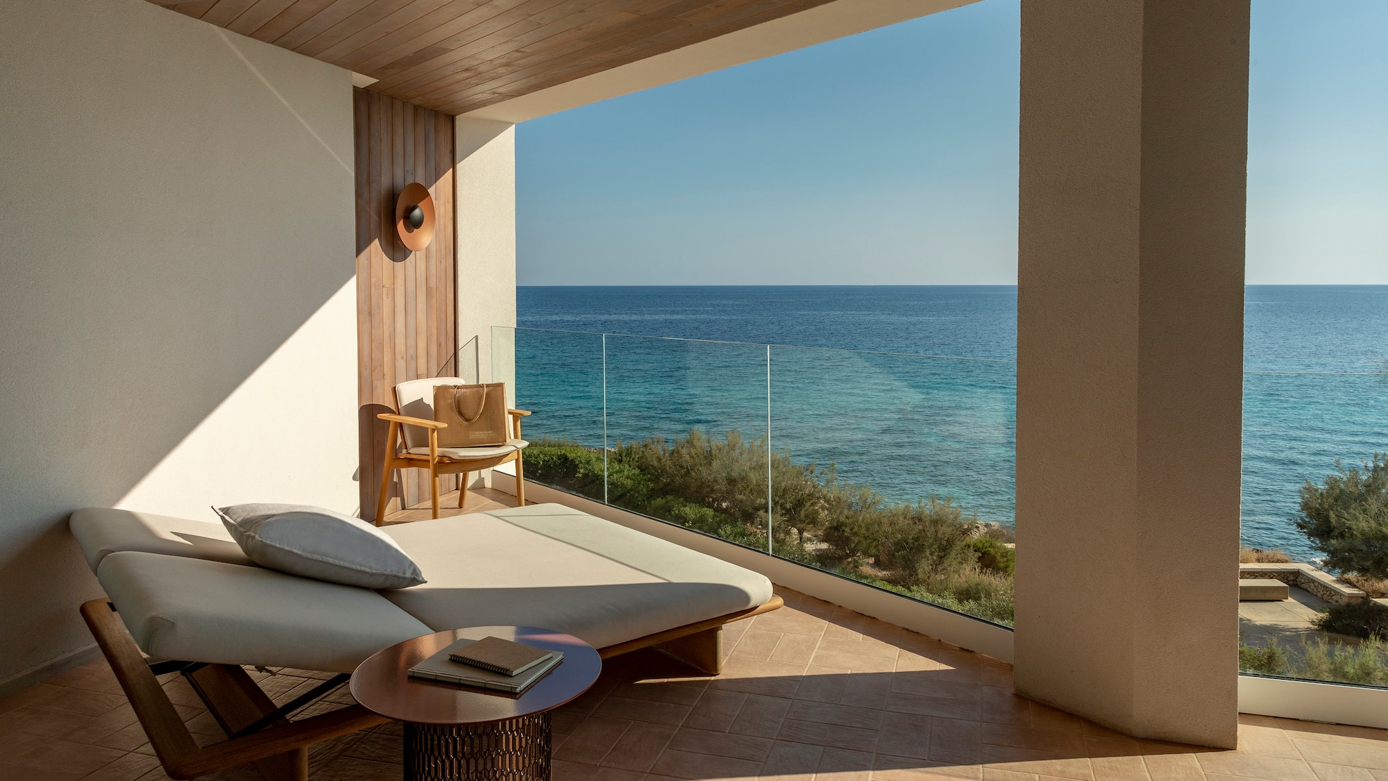 a lounge chair and a table overlooking the ocean