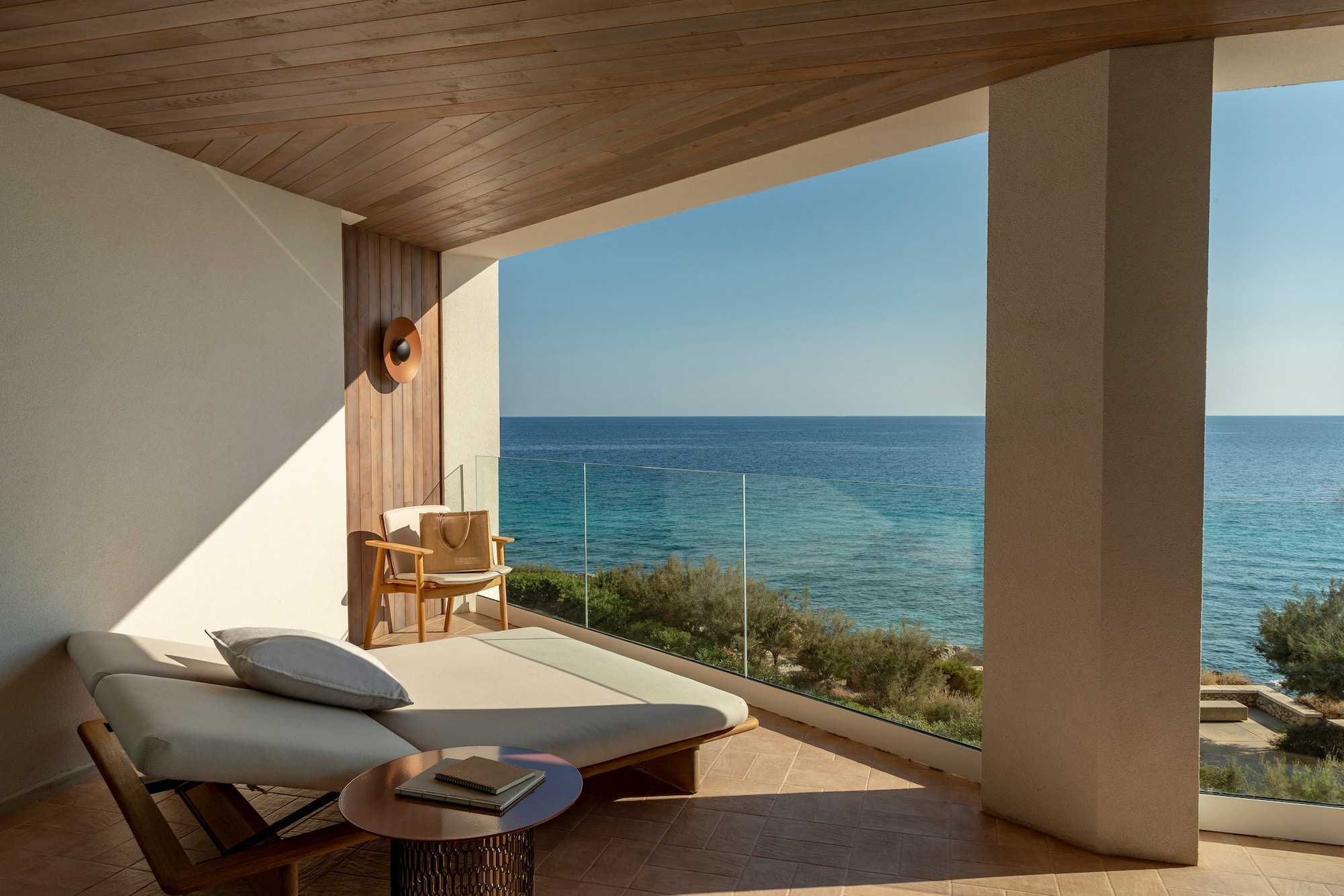 a lounge chair and a table overlooking the ocean