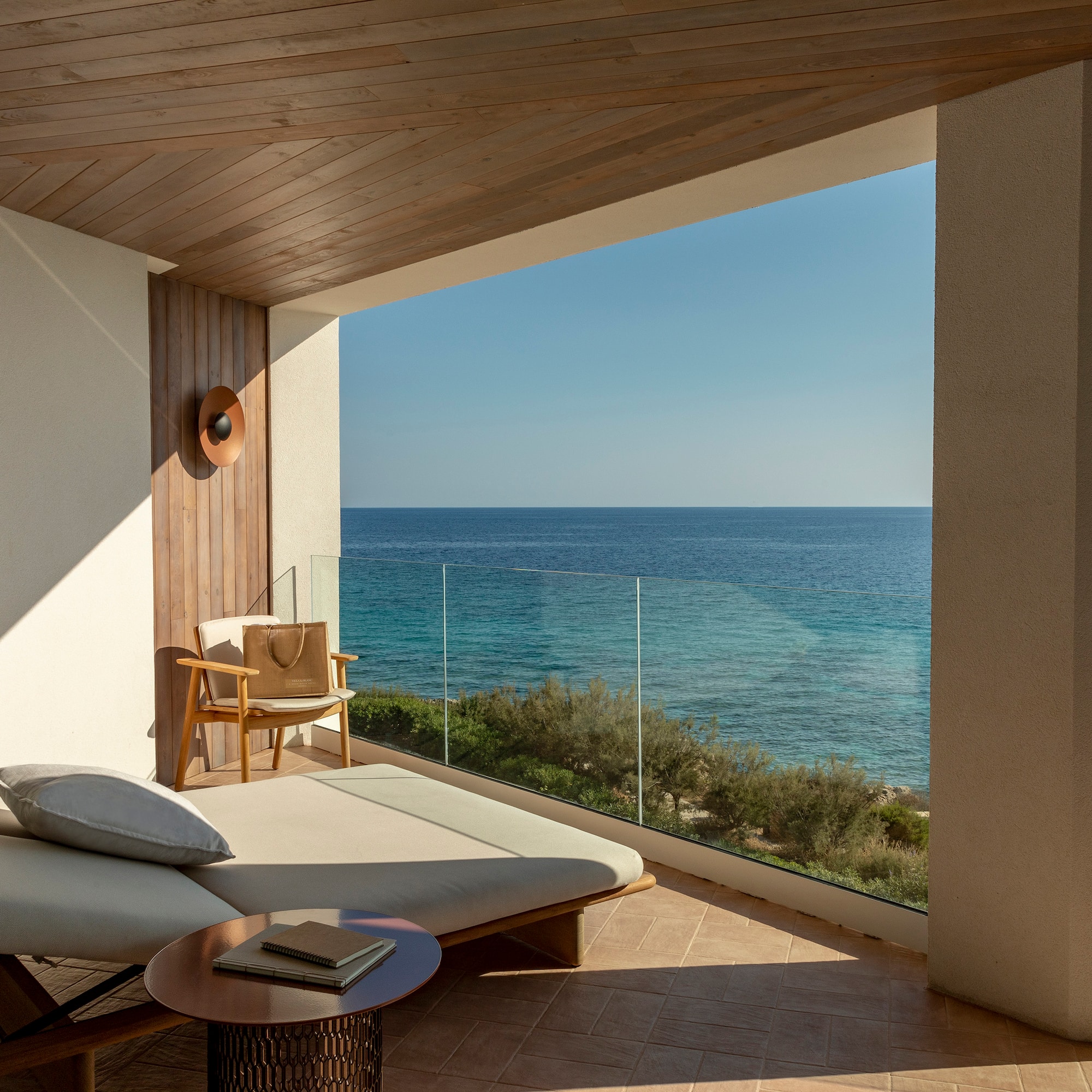 a lounge chair and a table overlooking the ocean