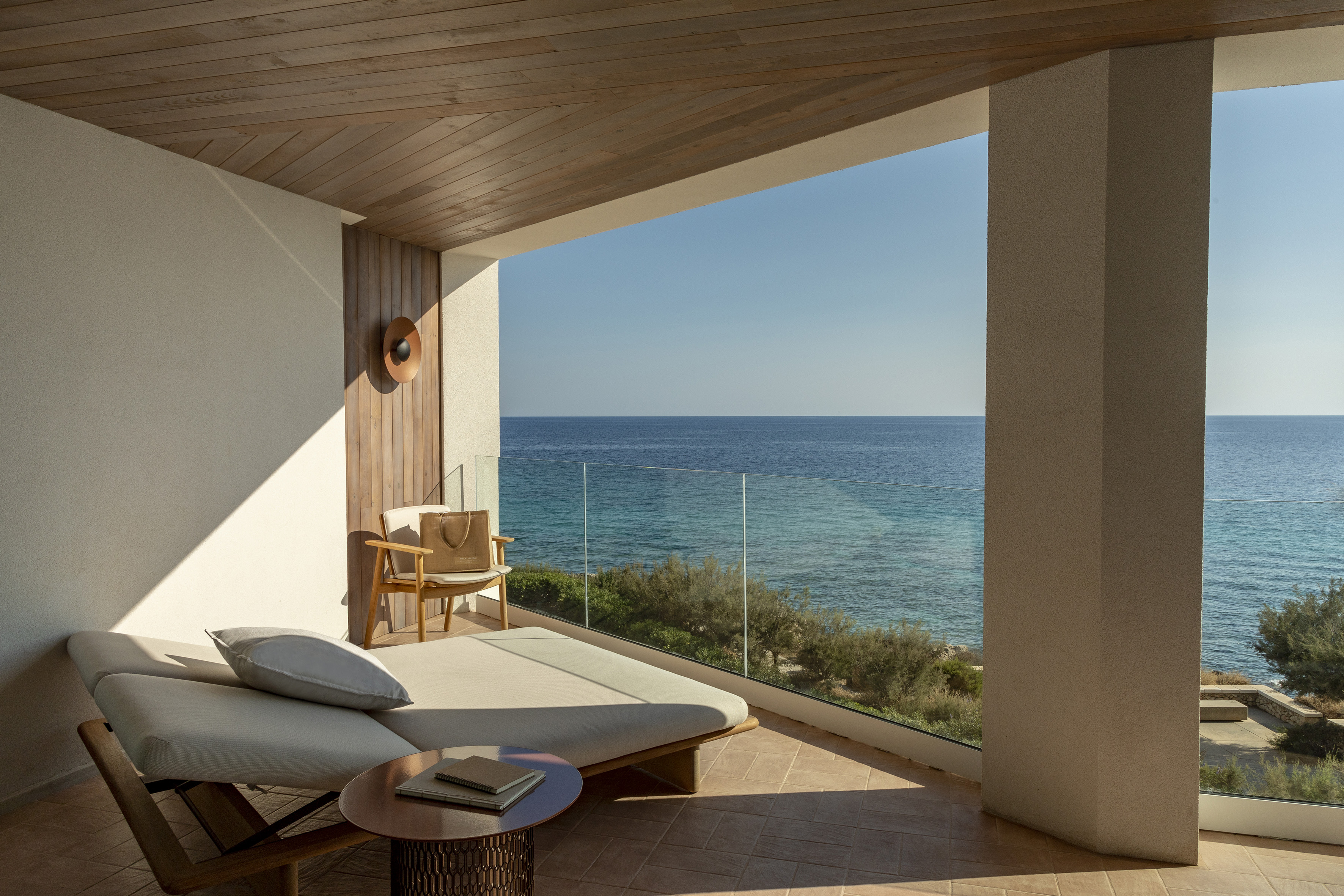 a lounge chair and a table overlooking the ocean