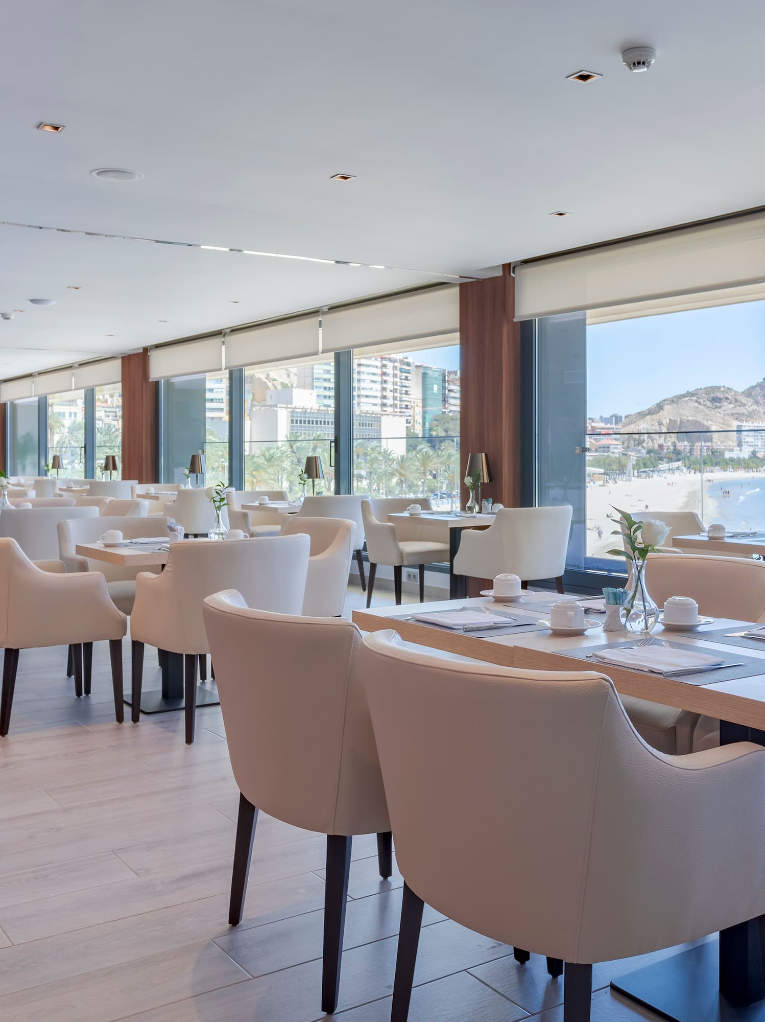 Comedor de hotel moderno con vista panorámica a la playa y al mar.