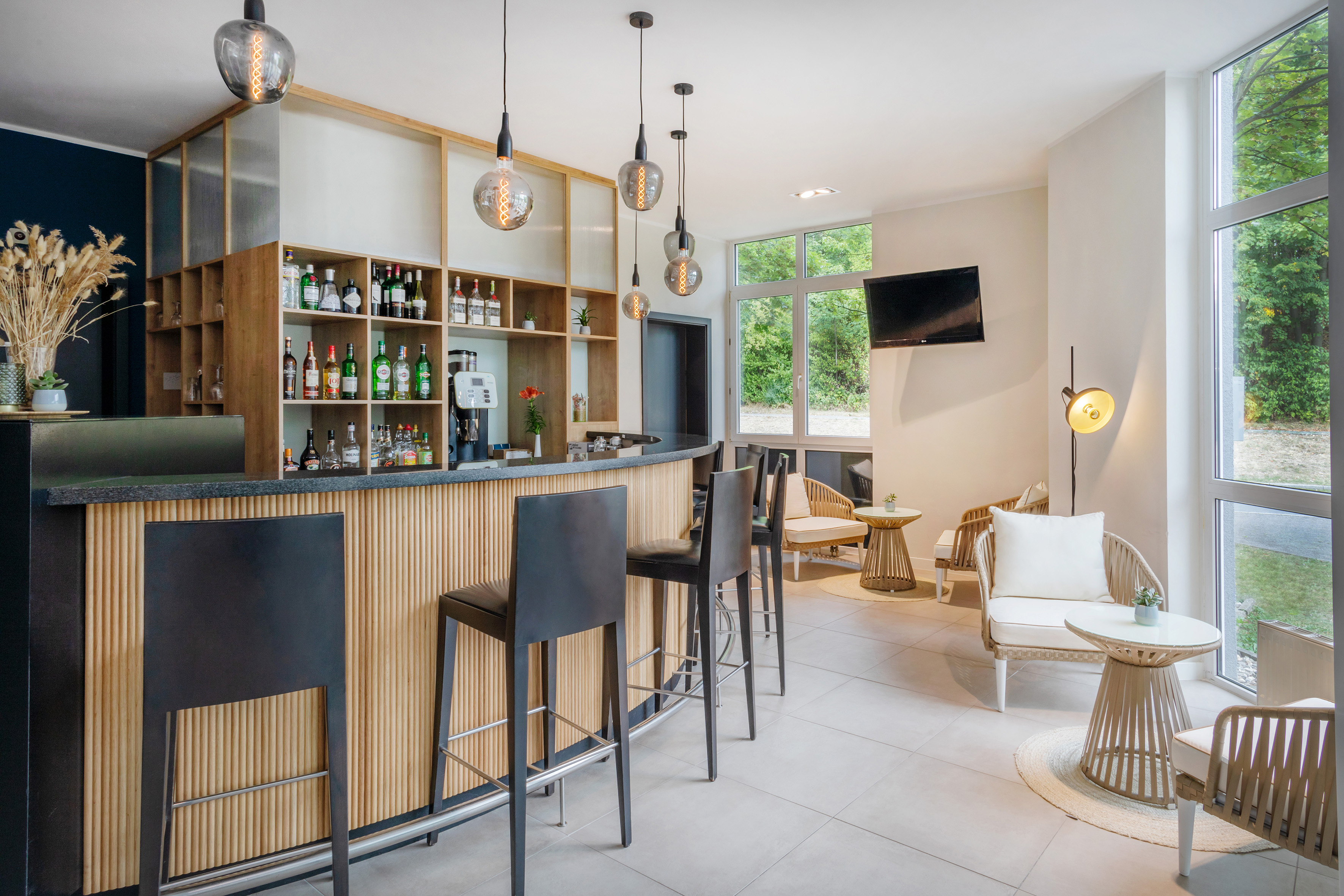 Modern hotel bar and lounge with black stools and bright lounge seating.
