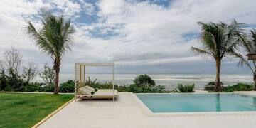 a pool with a lounge chair and palm trees
