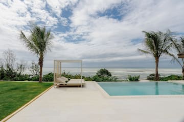 a pool with a lounge chair and palm trees