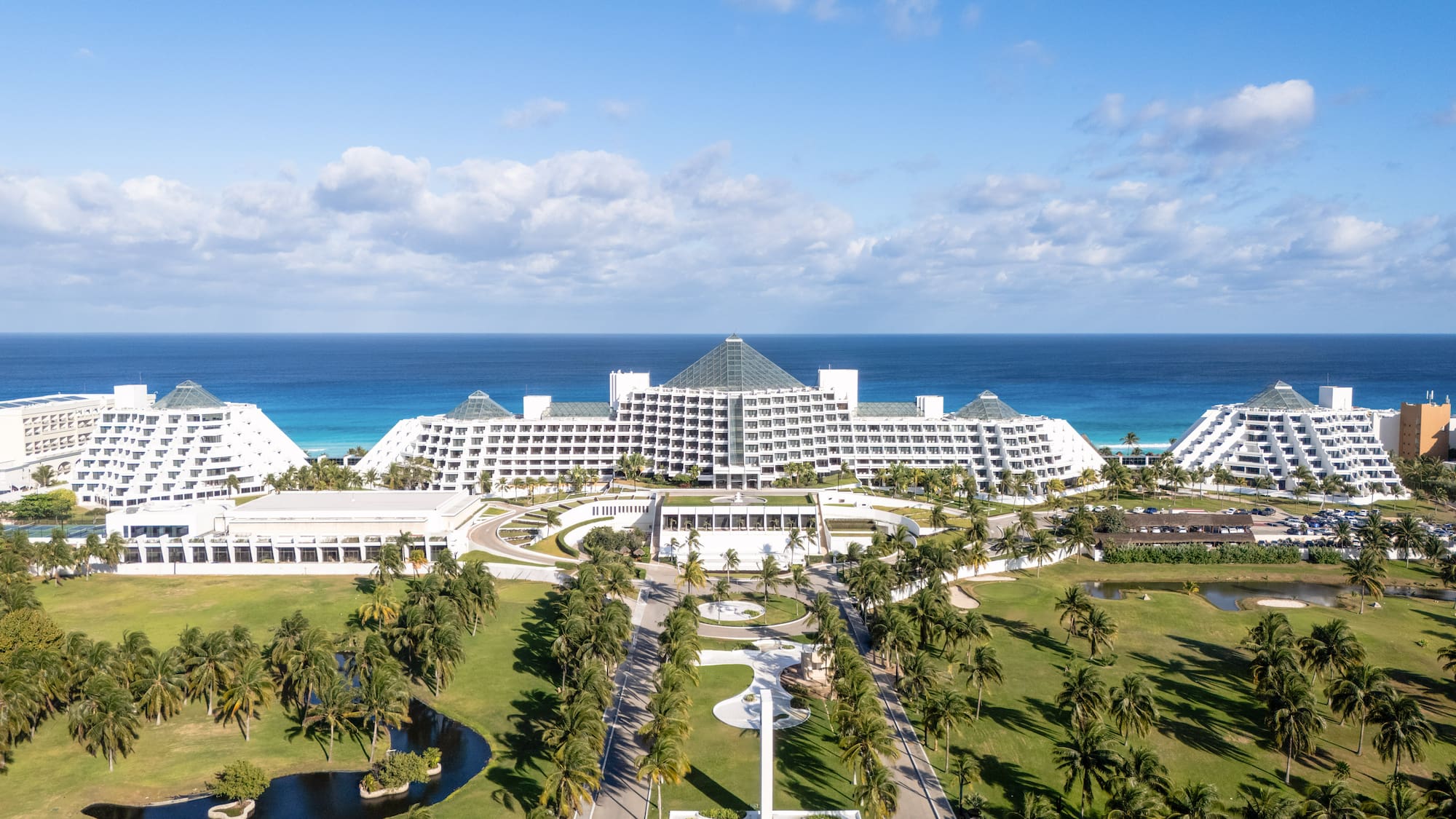 Cancun pyramid resort, oceanfront, with palm trees and golf course.
