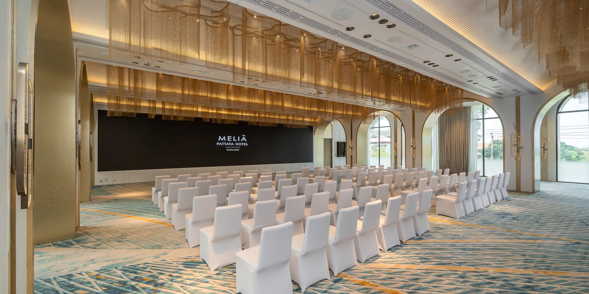 a room with white chairs and a black wall