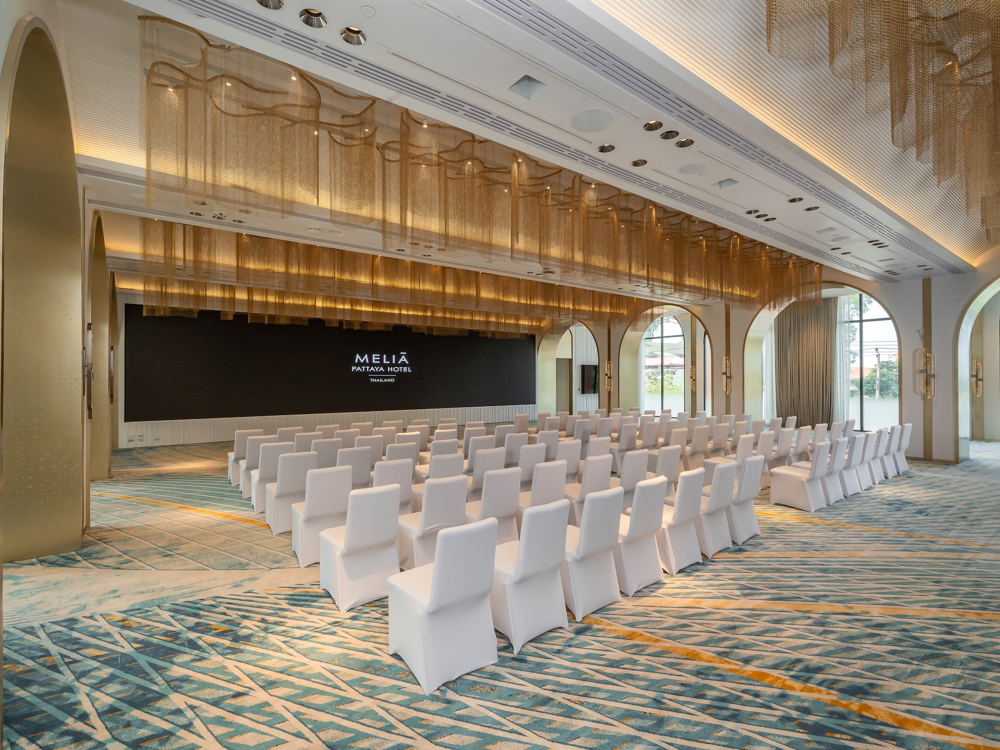a room with white chairs and a black wall.