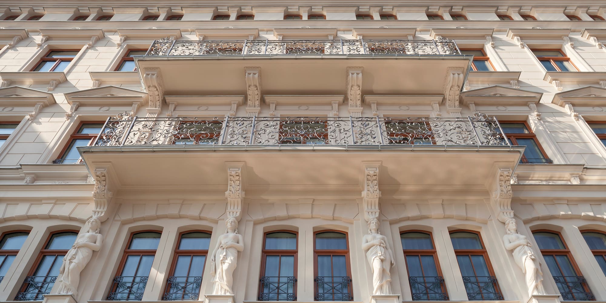Ornate historic building facade with decorative balconies and statues.