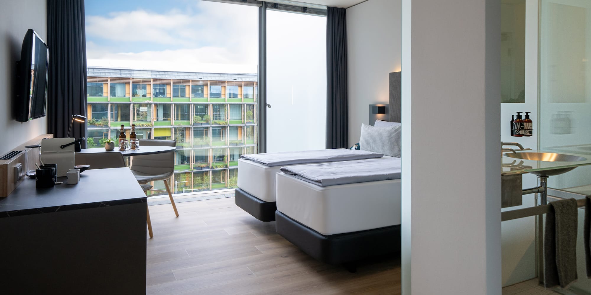 a room with two beds and a table and chairs