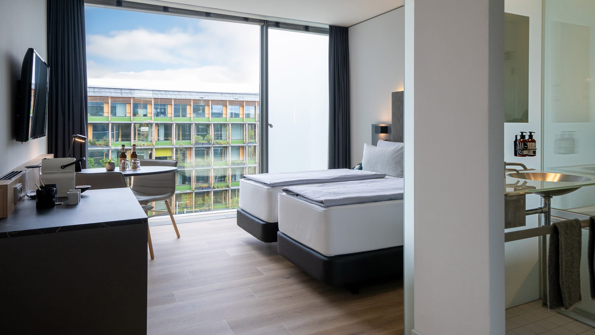 a room with two beds and a table and chairs