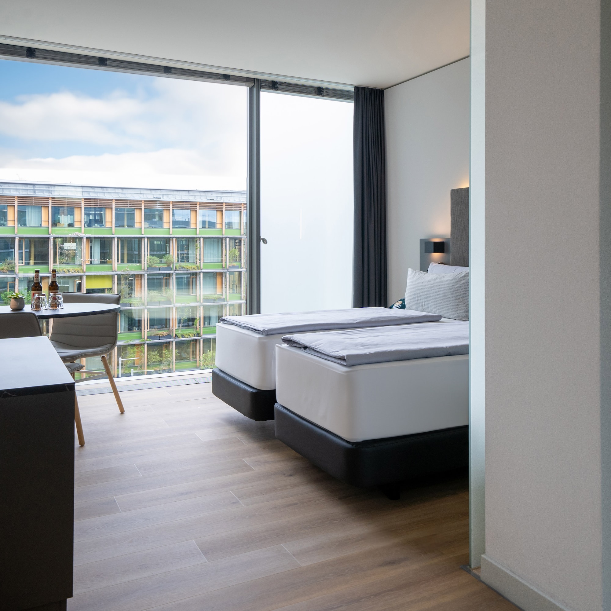 a room with two beds and a table and chairs