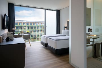 a room with two beds and a table and chairs