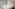 Bright hotel room with large bed, pool view, and balcony overlooking resort.