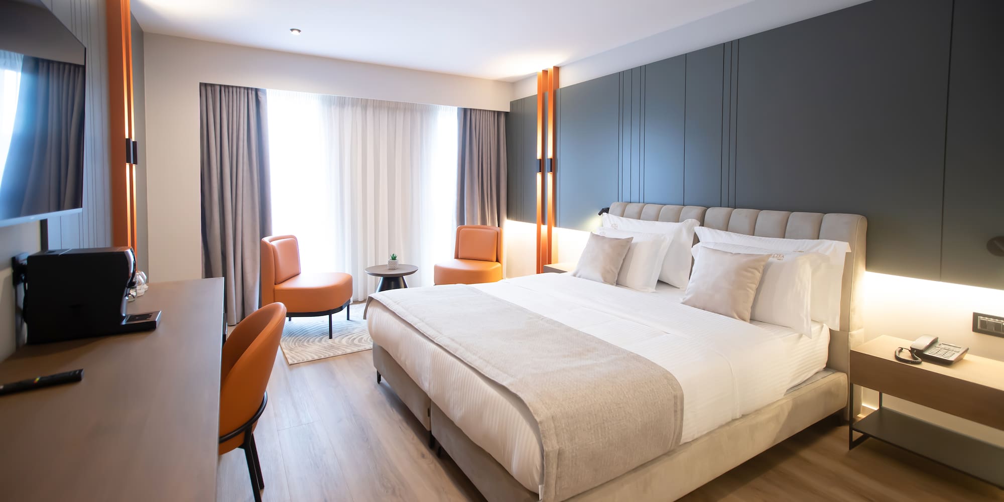 a room with a bed and chairs