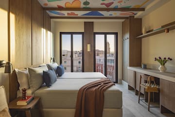 a room with a bed and a desk and a table