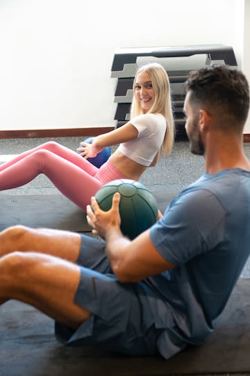 a man and woman sitting on the floor with a ball