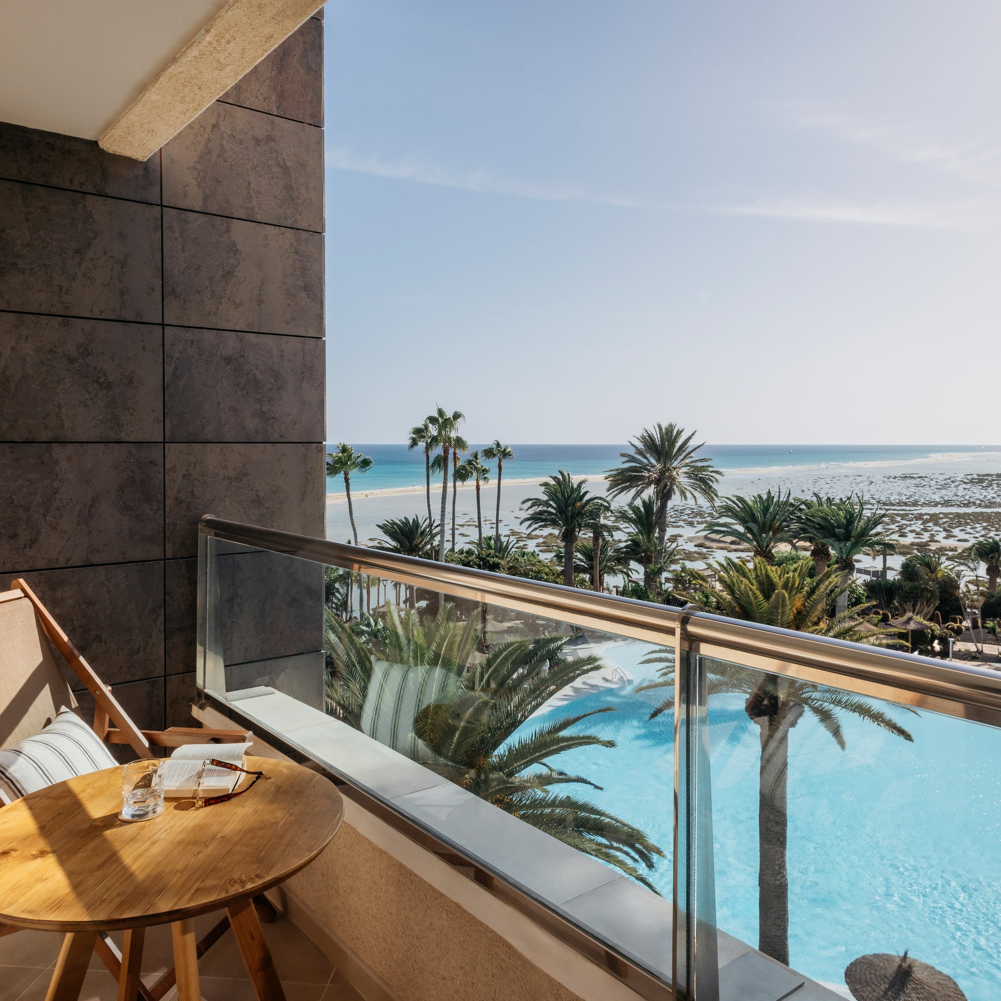 a balcony with a table and chairs overlooking a body of water