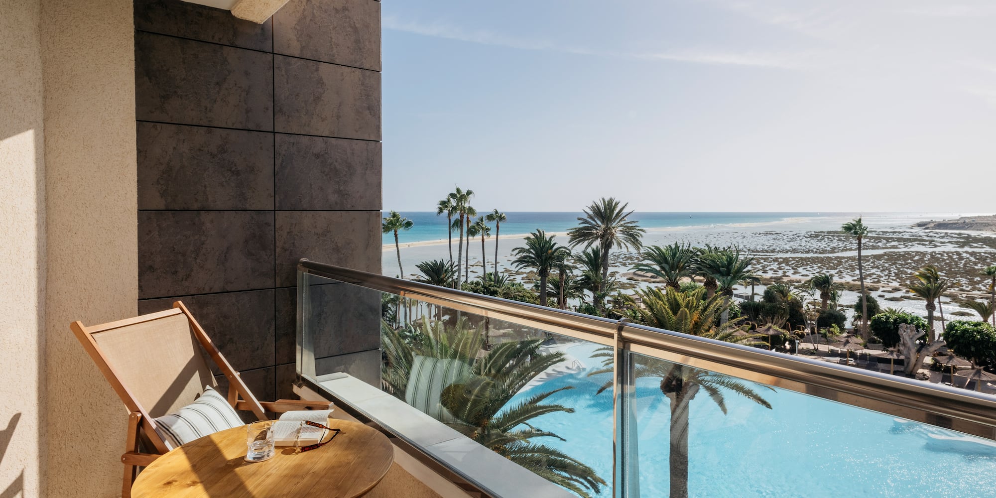 a balcony with a table and chairs overlooking a body of water