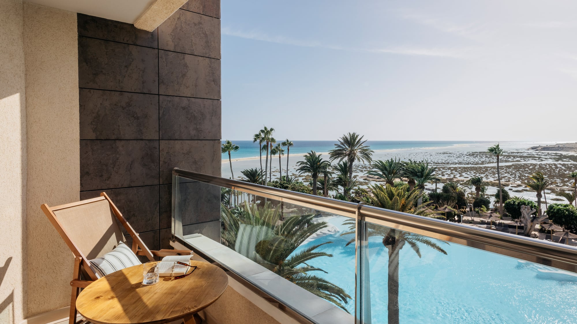 a balcony with a table and chairs overlooking a body of water
