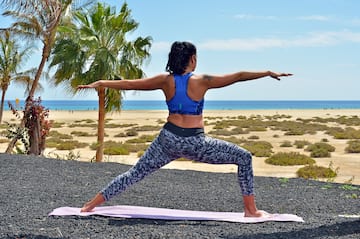 a woman doing yoga on a beach