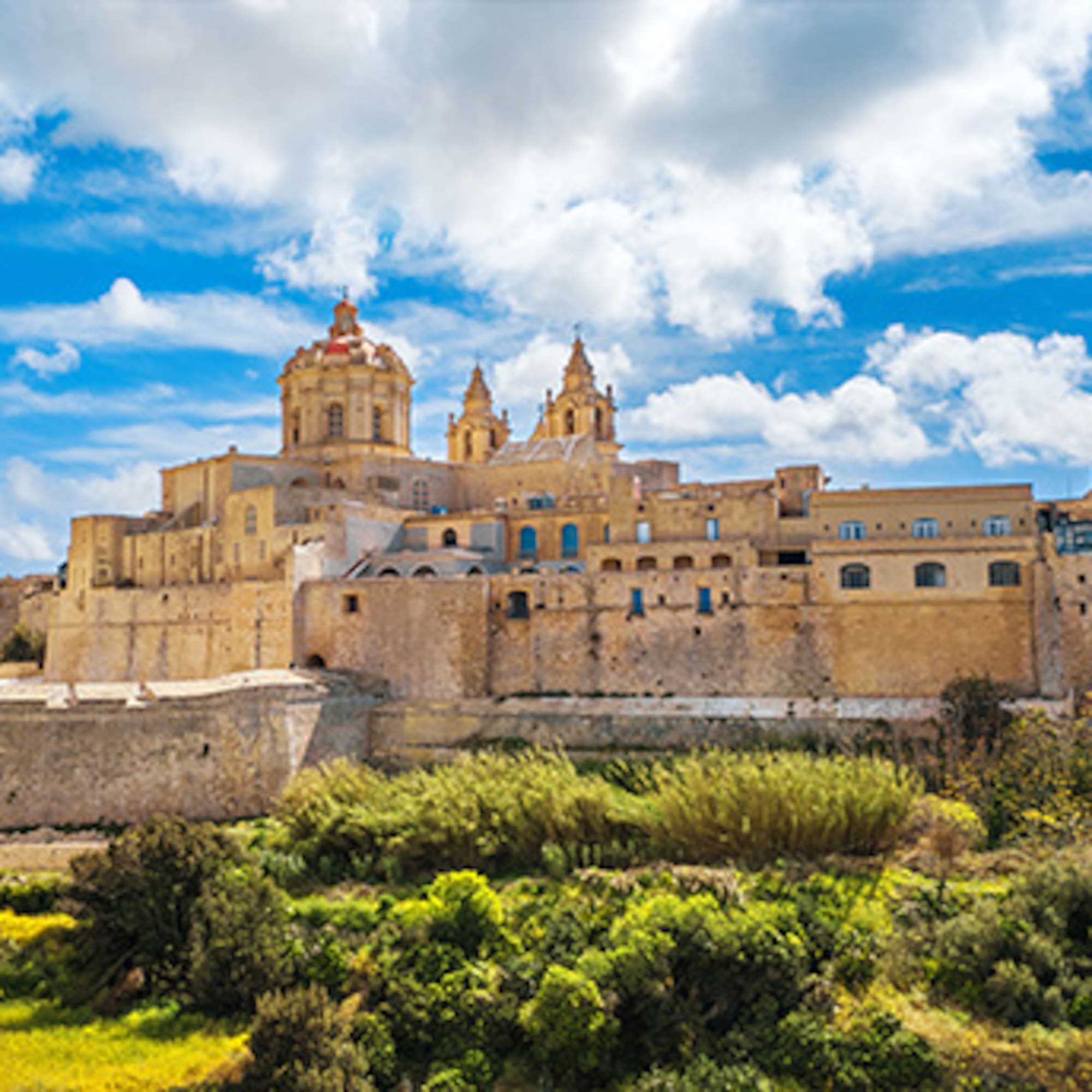 Mdina, Malta: historic fortified city with cathedral domes against blue sky.