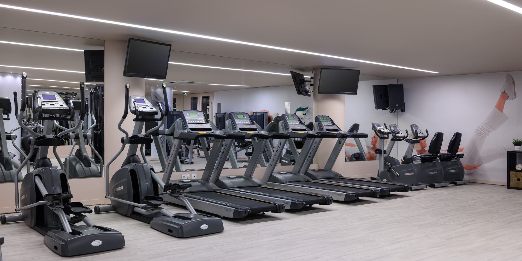 a gym with treadmills and a mirror