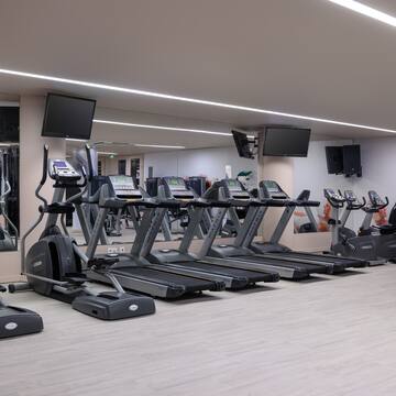 a gym with treadmills and a mirror