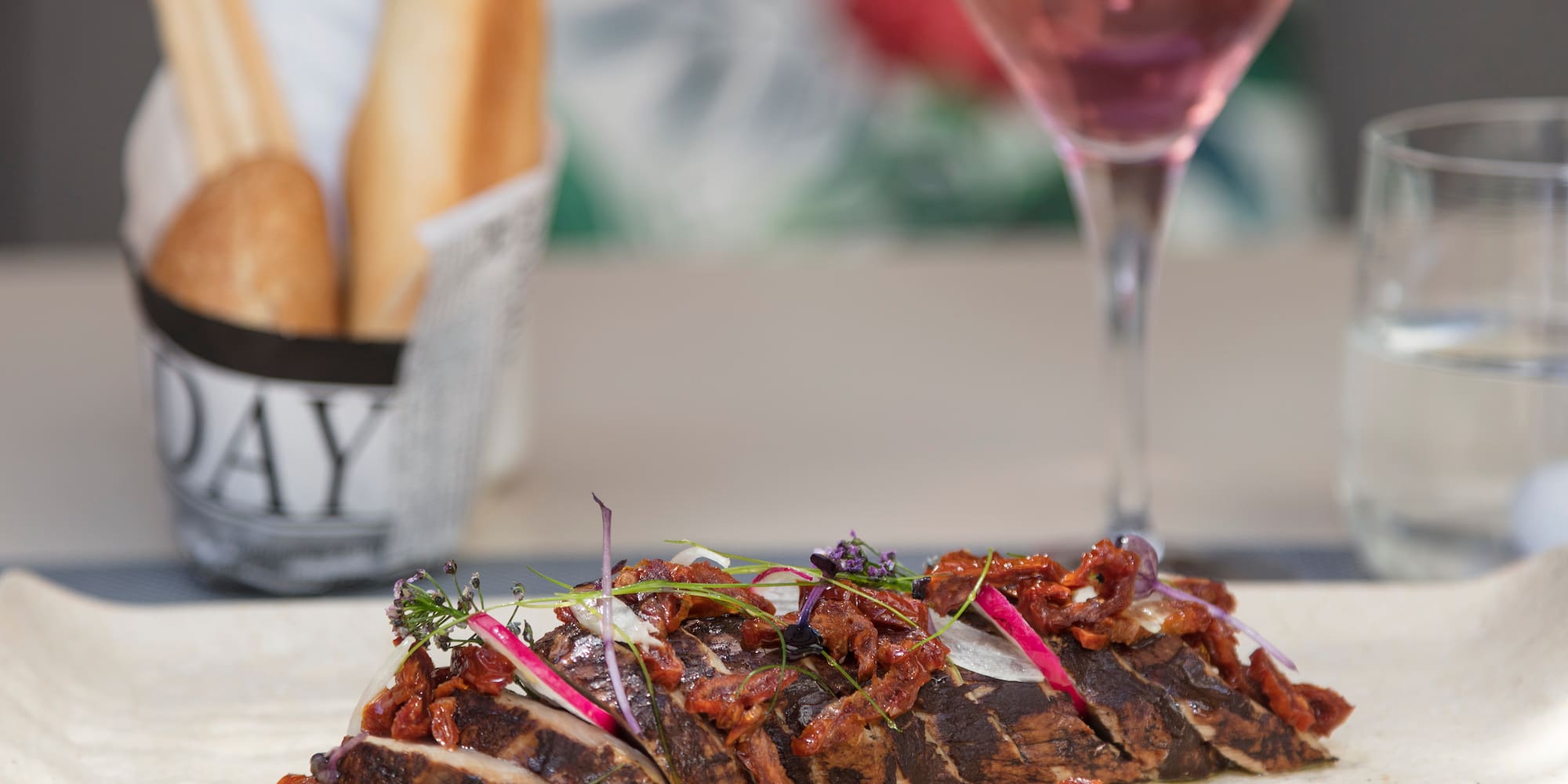 a sliced meat with onions and herbs on a table