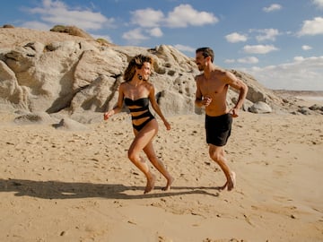 a man and woman running on a beach