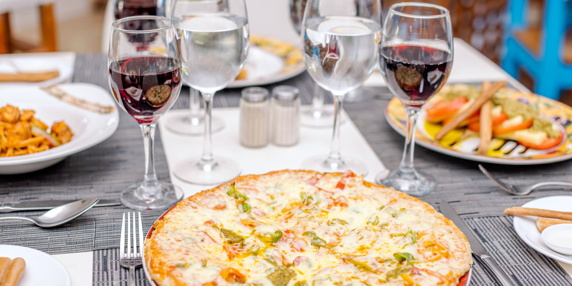 a pizza and wine glasses on a table