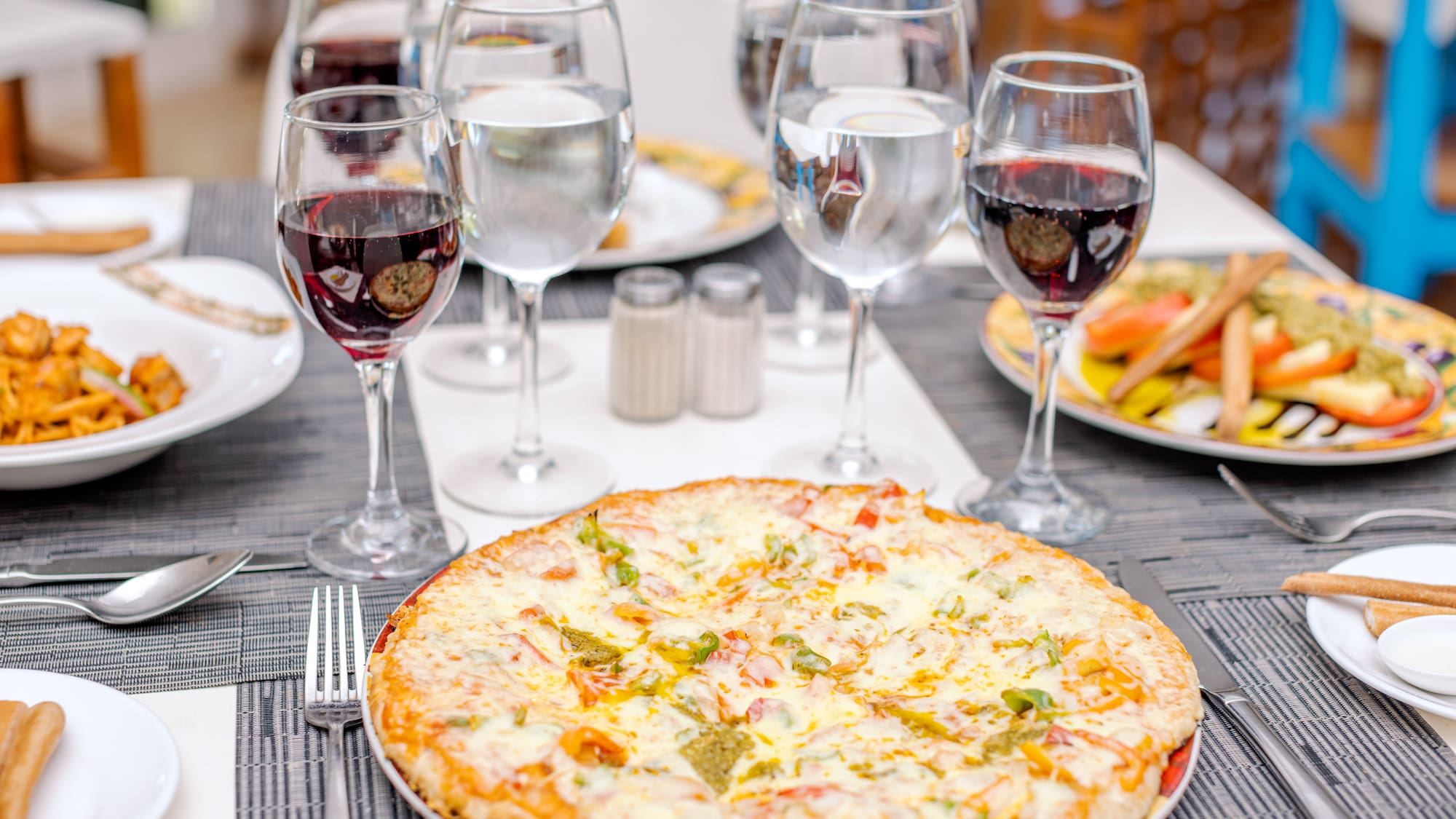 a pizza and wine glasses on a table