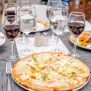 a pizza and wine glasses on a table