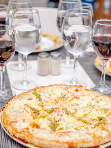 a pizza and wine glasses on a table