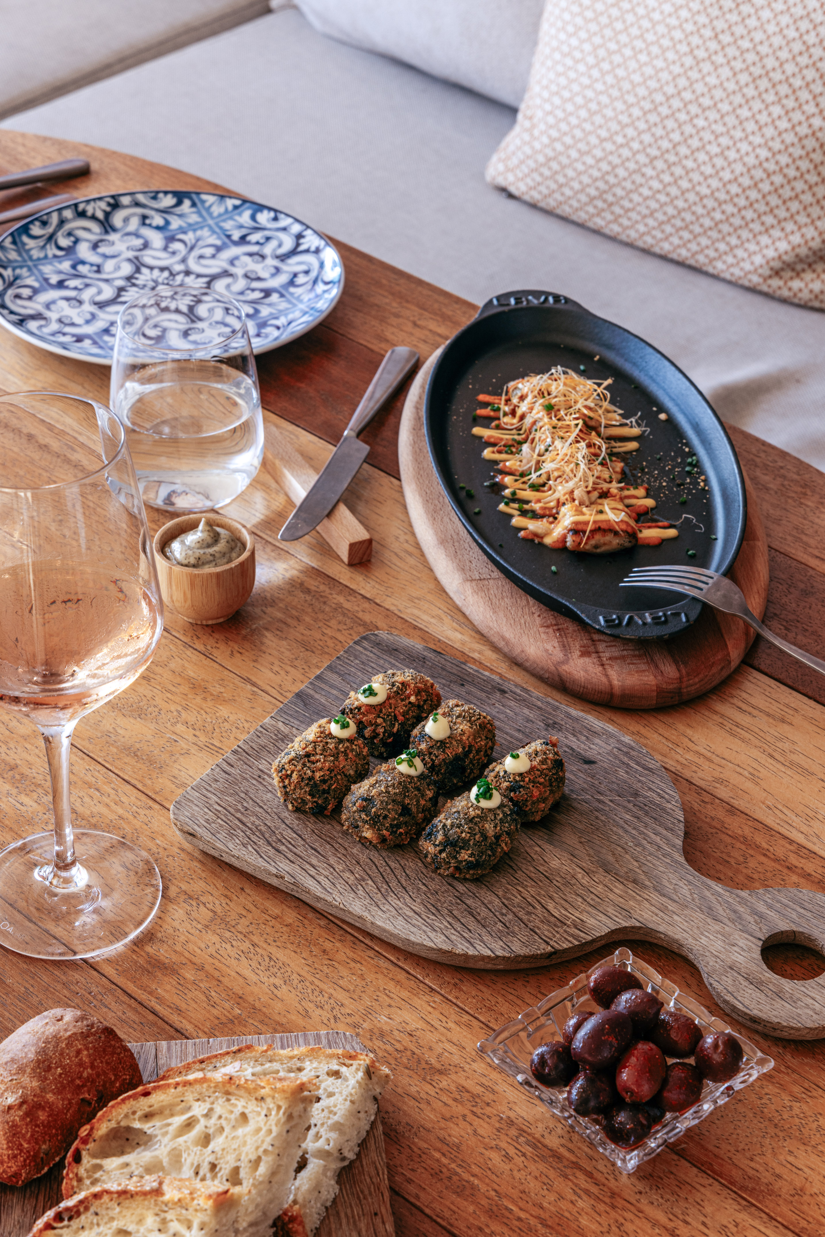 Tapas dinner: crispy croquettes, grilled skillet dish, bread, olives, rose wine.