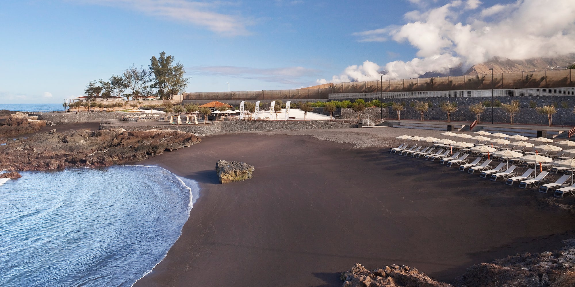 a beach with chairs and rocks