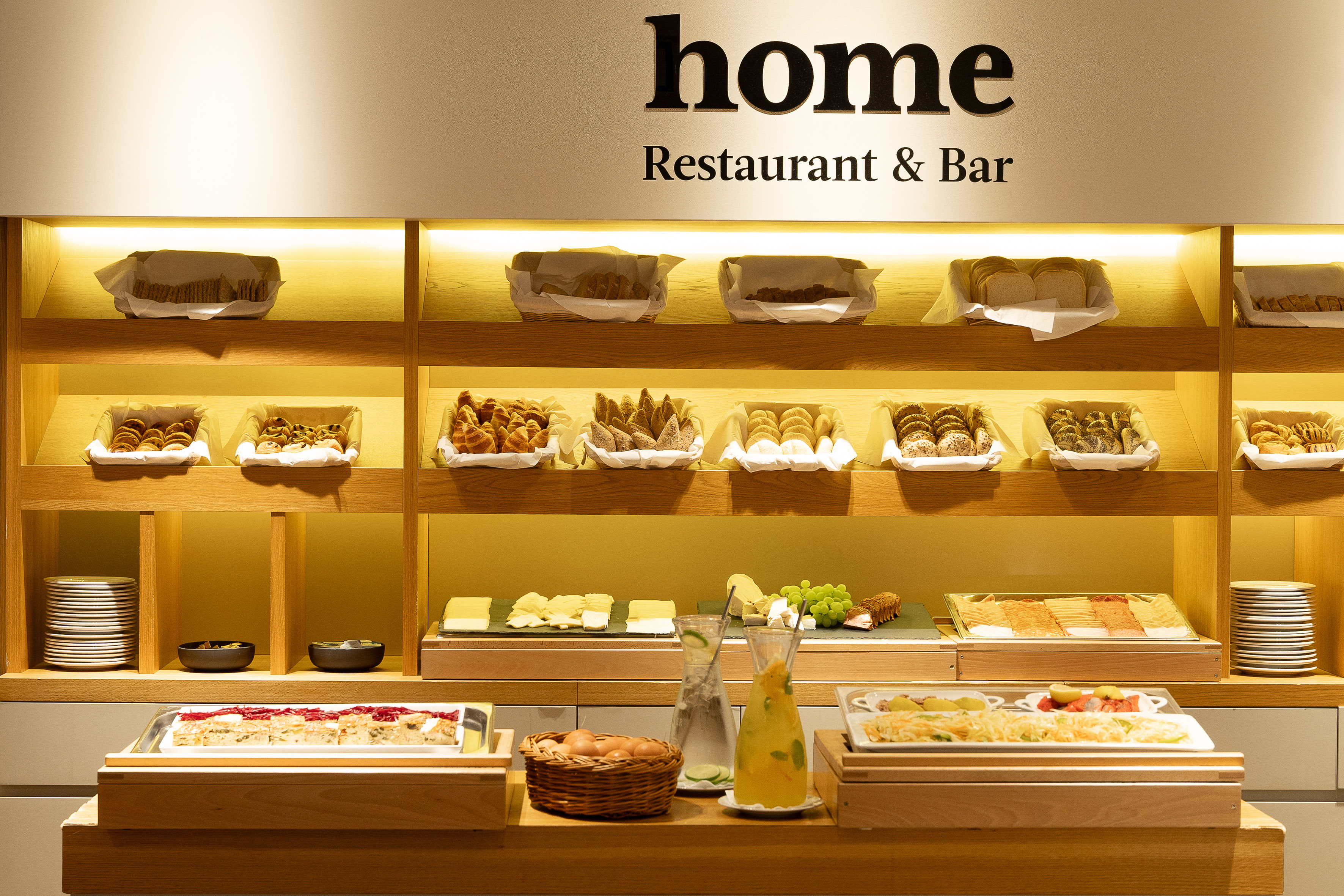 Home Restaurant & Bar breakfast buffet: pastries, bread, cheese, and juices.
