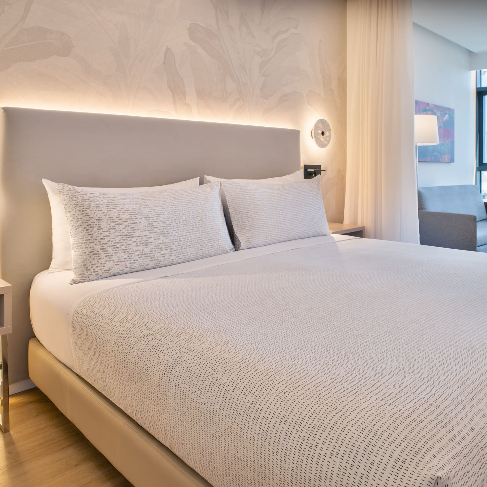 a bed with white sheets and pillows