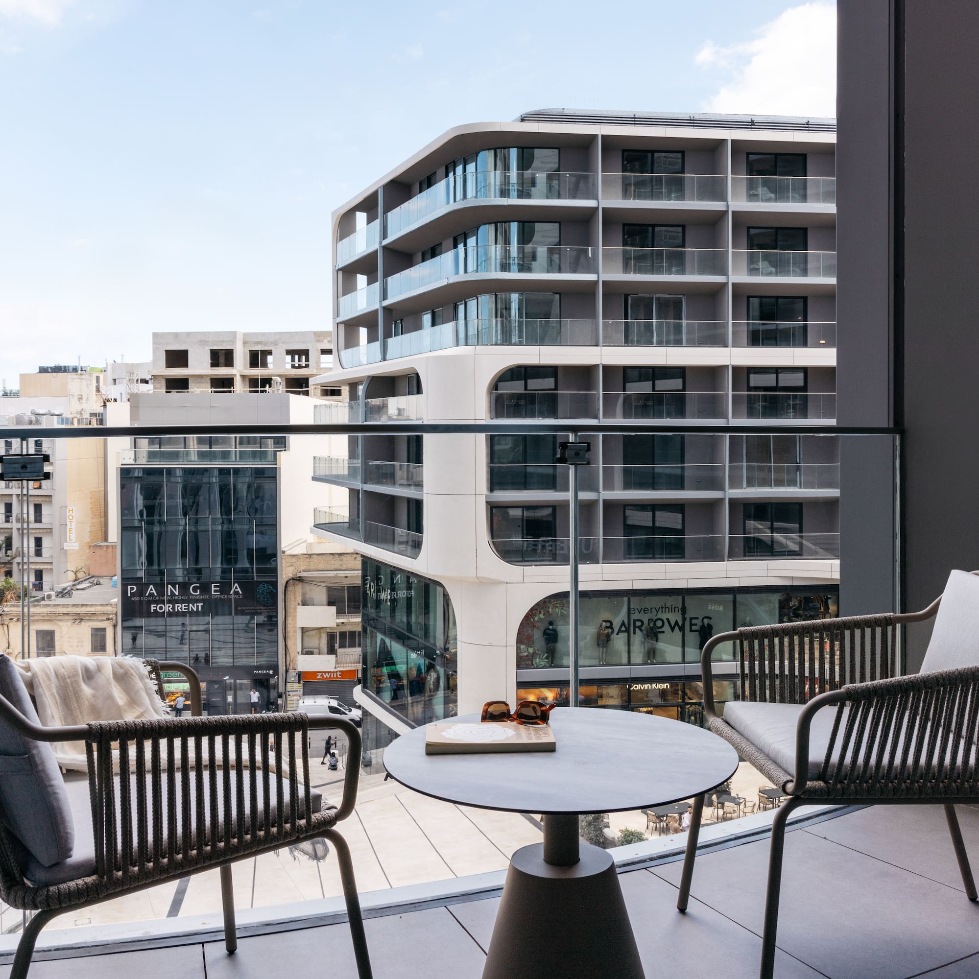 a balcony with chairs and a table