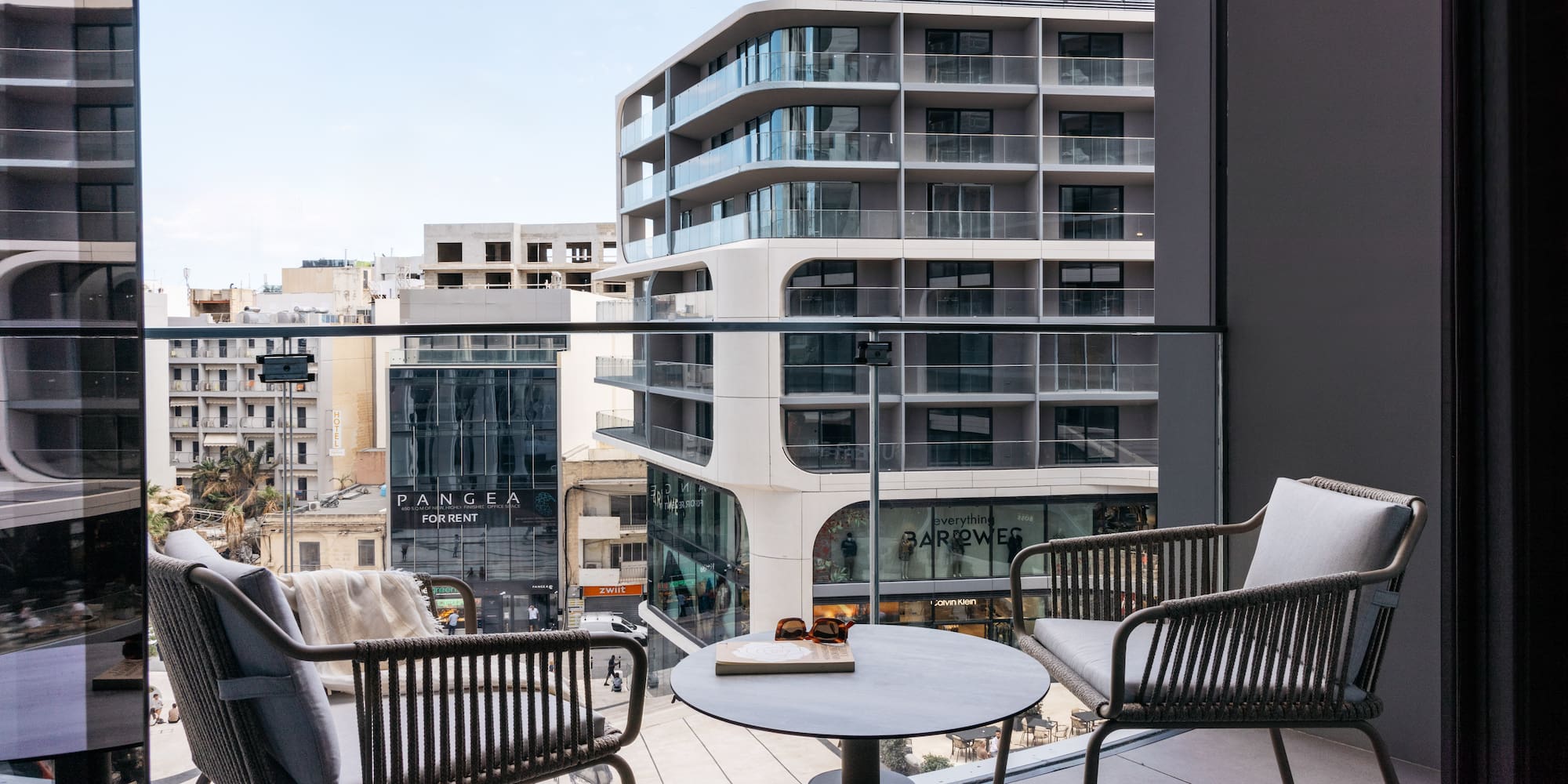 a balcony with chairs and a table