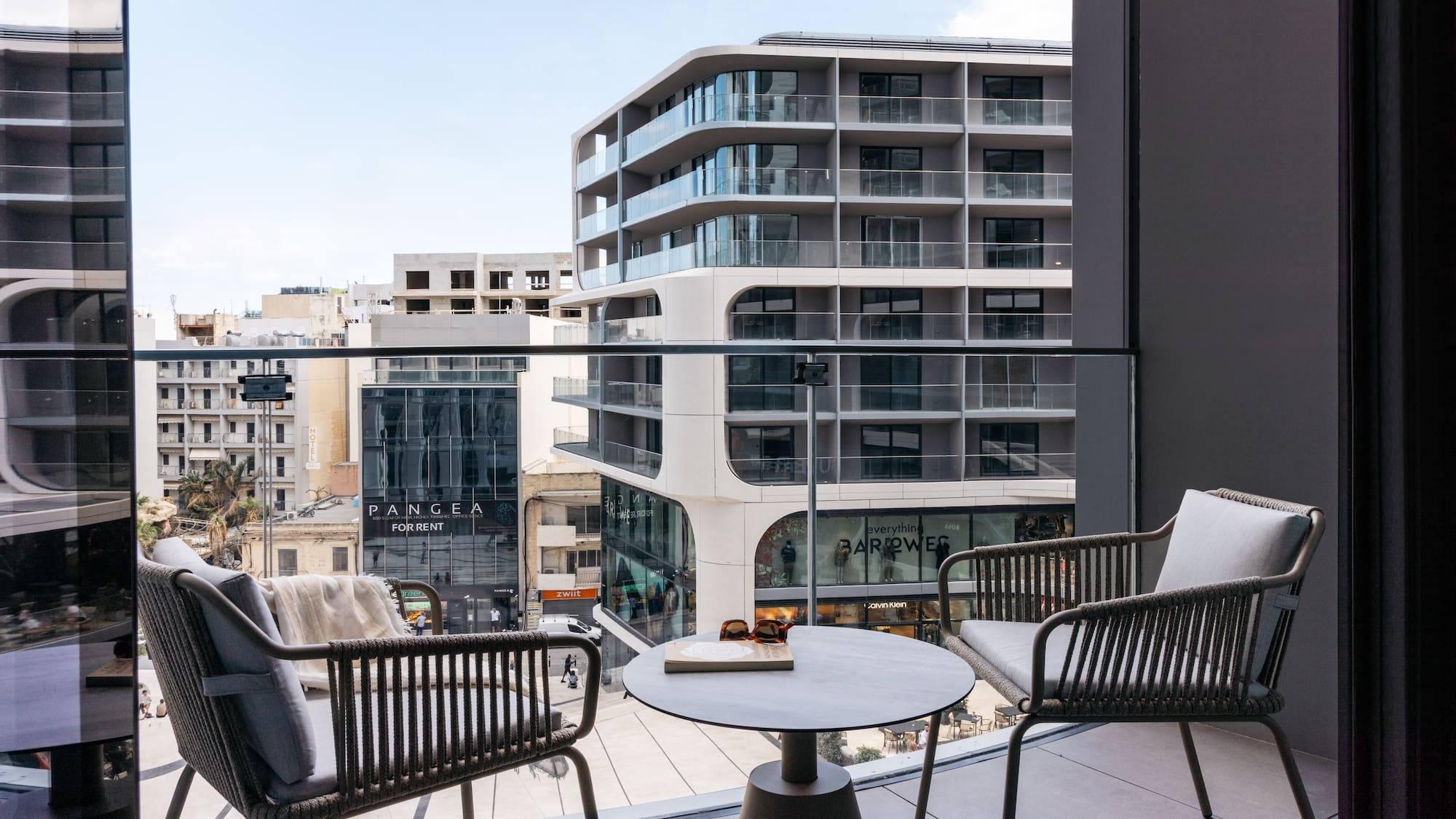 a balcony with chairs and a table