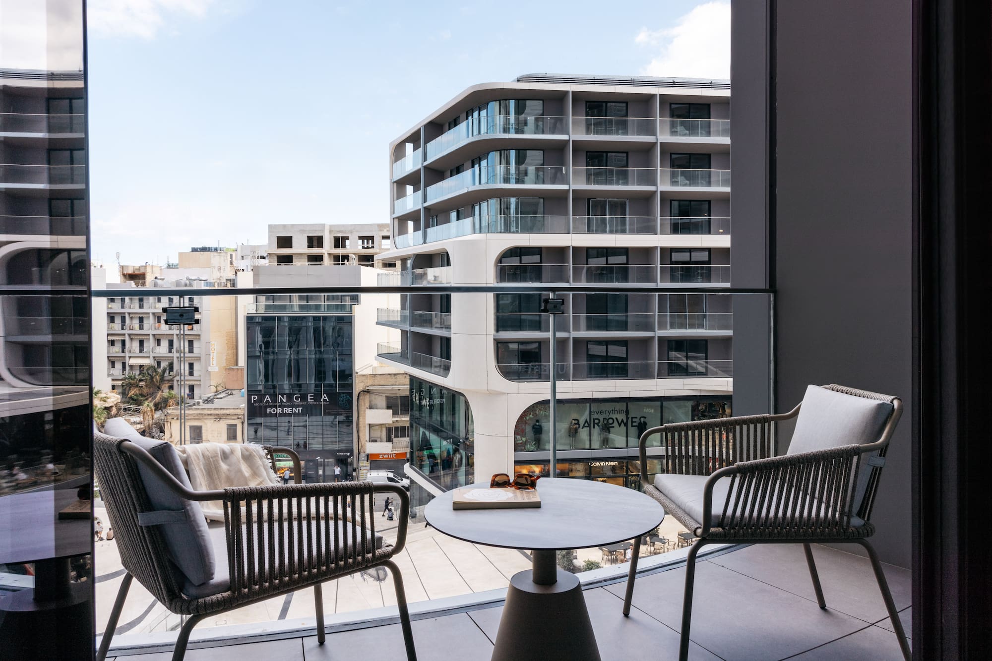 a balcony with chairs and a table