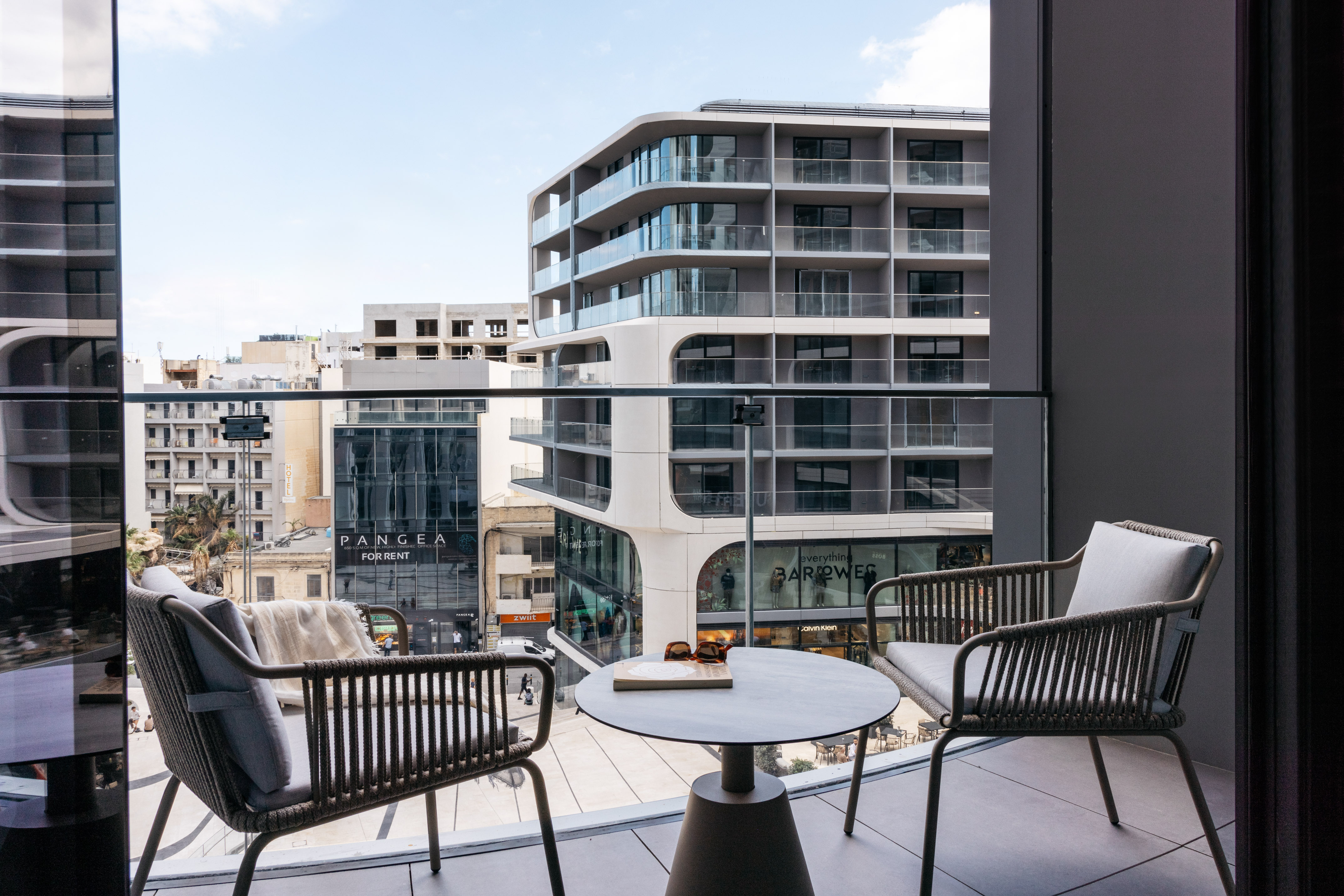 a balcony with chairs and a table