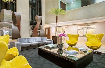 a room with a couch and a table with chairs and a palm tree