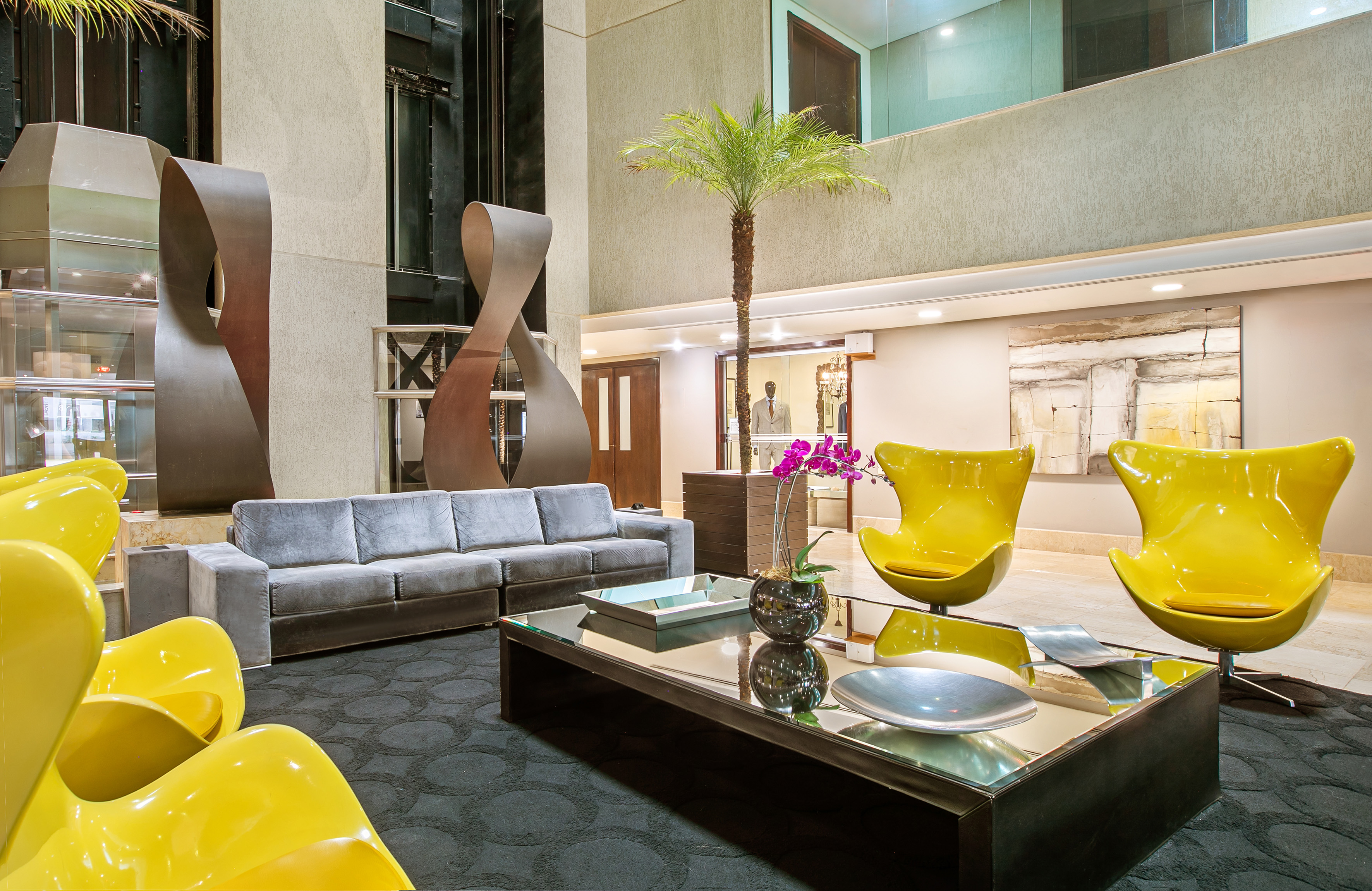 a room with a couch and a table with chairs and a palm tree