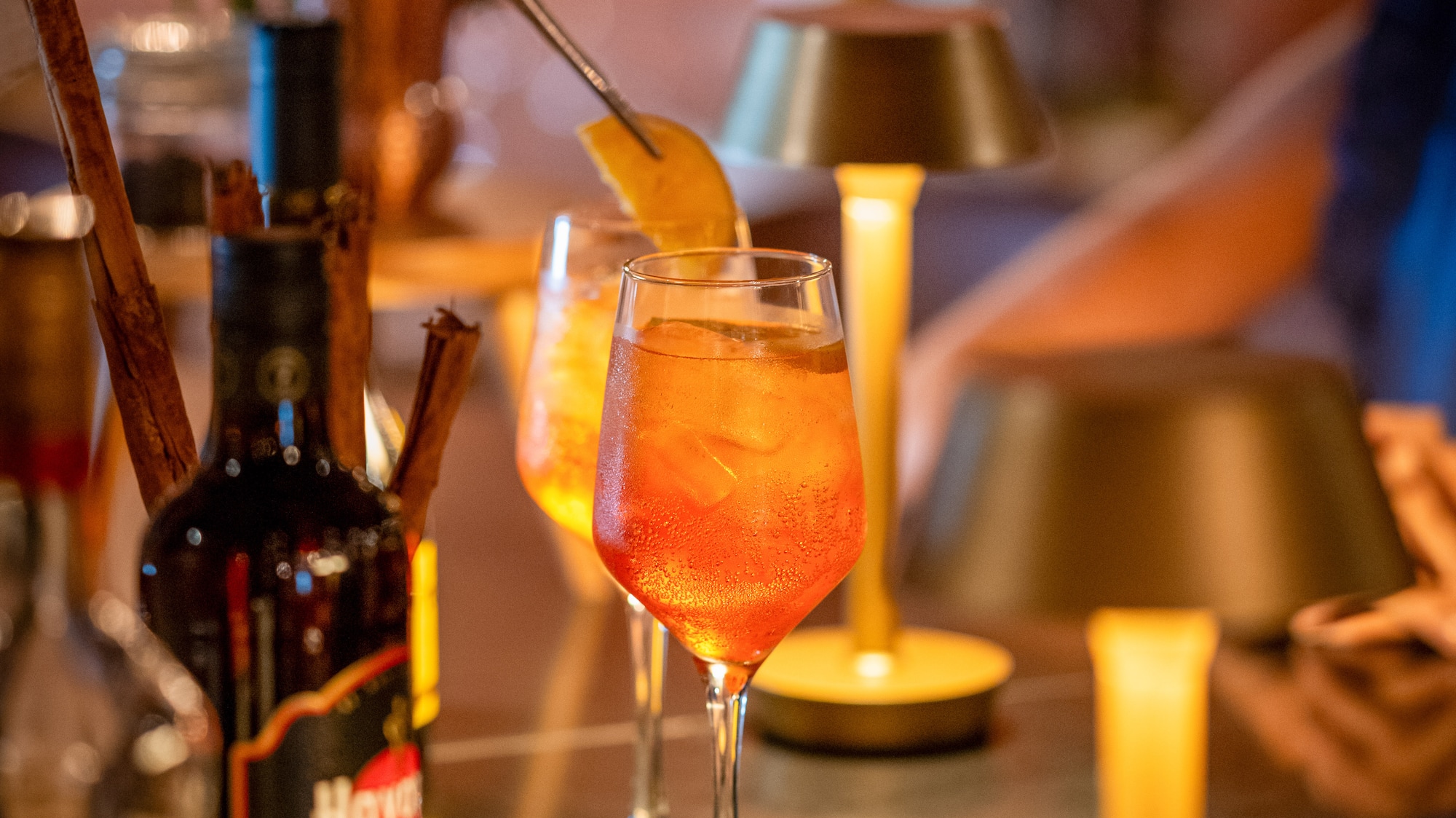 a person putting a lemon into a glass of alcohol