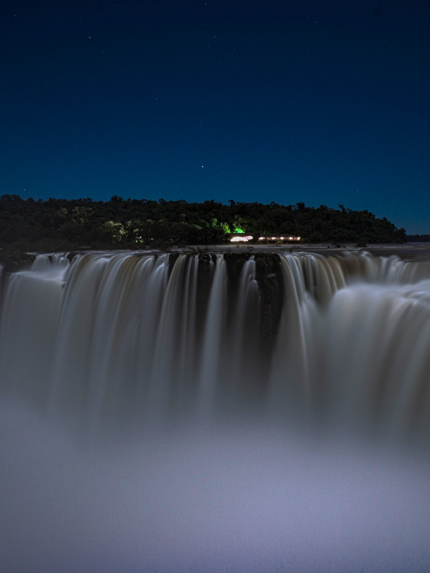 a waterfall with a forest in the background